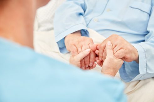 nurse holding elderly's hands