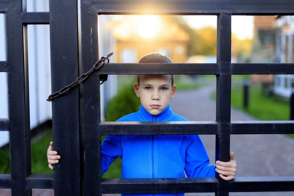 child isolated behind the gate