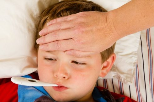 Child with flu resting in bed