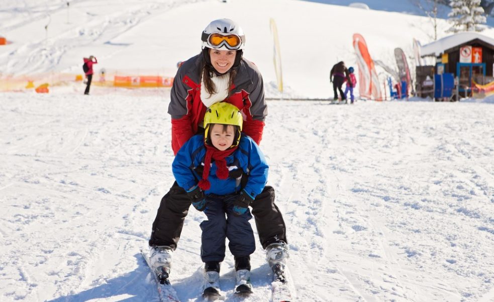 Mother and child snowboarding