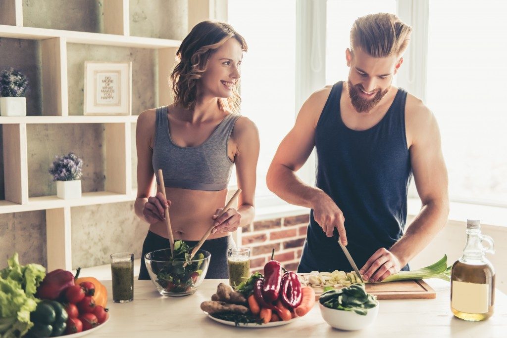 couple in workout clothes preparing high in protein snacks