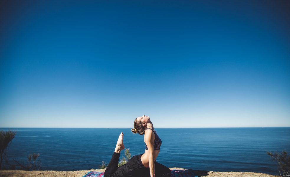 woman doing yoga near the sea