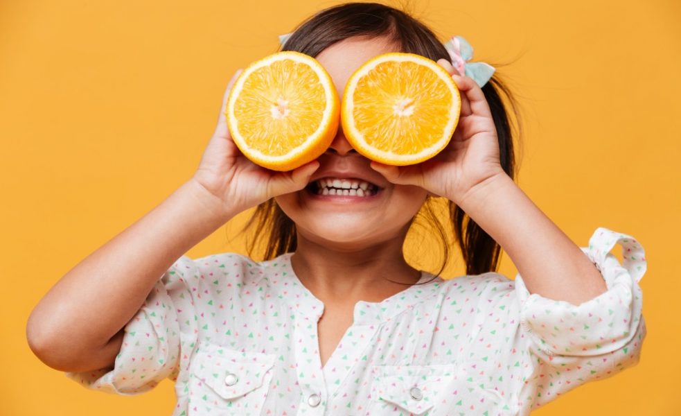 kid holding an orange